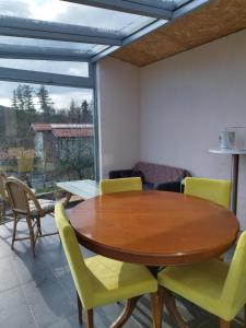 a dining room with a wooden table and yellow chairs at Come a casa B&B in Montegrino Valtravaglia