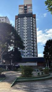 a tall building with a parking lot in front of it at Studio Moderno com Piscina a 15min a pé do Nubank Parque-117 in São Paulo