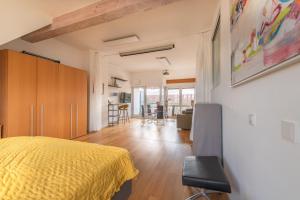 a bedroom with a yellow bed and a living room at Stylish Loft Apartment with Designer Bathroom & Balcony in Berlin