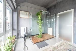 a bathroom with a glass shower with a plant at Stylish Loft Apartment with Designer Bathroom & Balcony in Berlin +24 photos