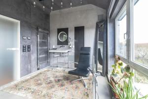 a room with a chair and a desk and window at Stylish Loft Apartment with Designer Bathroom & Balcony in Berlin