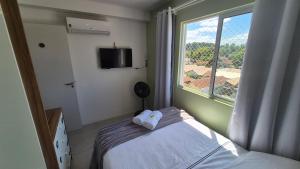 a bedroom with a bed and a large window at Apartamento 2 quartos Blumenau a 10 minutos da Vila Germânica in Blumenau +26 photos