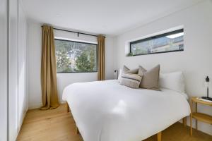 a bedroom with a large white bed and a window at Spacious 2BR Retreat, Scenic Views, Modern & New in Whistler