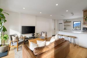 a living room with a couch and a table at Spacious 2BR Retreat, Scenic Views, Modern & New in Whistler