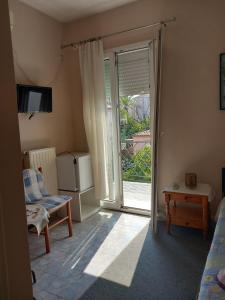 a bedroom with a sliding glass door to a patio at THALIA'S GARDEN in Mytilene