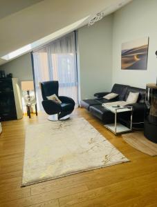ein Wohnzimmer mit Sofa, Sessel und Teppich in der Unterkunft Jūrmaris in Neringa