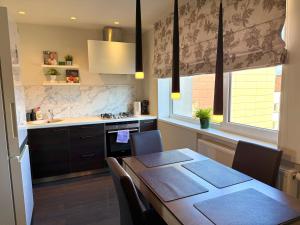 a kitchen with a dining table and a kitchen with a sink at Birštonas Relax Apartment in Birštonas