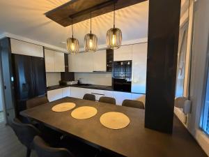 a kitchen with a dining table with chairs and lights at Bella Mela 2 in Tuzla