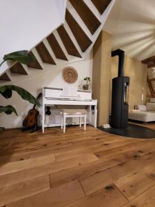 a living room with a piano and a wood floor at Kleine Oase in Ettenheim