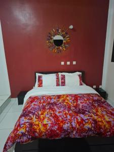 a bedroom with a large bed with a red wall at Complexe Hôtelier Lassavane in Jacqueville +27 photos