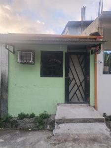 a green house with a door and a window at Green Pod 2 - Surigao City in Surigao