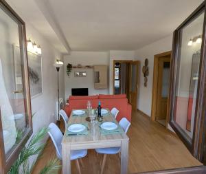 a living room with a table and a red couch at Apartamento Asueto Ordesa in Broto