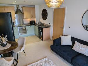 a living room with a couch and a kitchen at Neptune 27 in Swansea