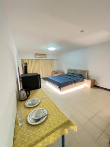 a bedroom with a bed and a table with plates on it at Bts studio rooms in Bangna