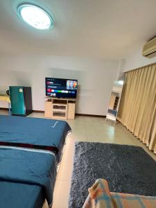 a room with two beds and a flat screen tv at Bts studio rooms in Bangna