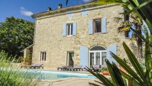 a stone house with a pool in front of it at La Bastide de Vallon in Vallon-Pont-dʼArc