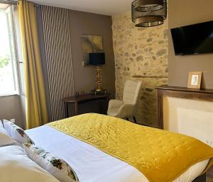 a hotel room with a bed and a chair at La Bastide de Vallon in Vallon-Pont-dʼArc