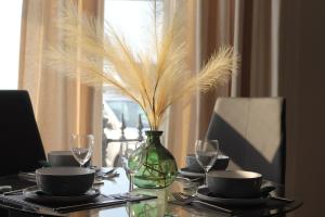 a dining room table with a vase with feathers in it at Stunning Seafront Apartment in Aberystwyth