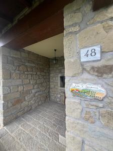 a stone wall with a sign on it at L'Orto di Scarpaccia in Pratovecchio