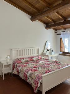 a bedroom with a bed and two tables and a mirror at L'Orto di Scarpaccia in Pratovecchio