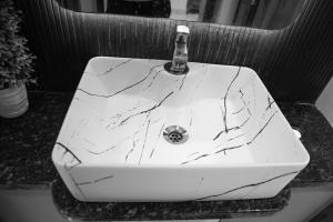a white bathroom sink with a marble counter top at Maneva Comforts in Mangalore +8 photos