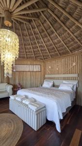 a bedroom with a large white bed with a chandelier at Positano Village in Canoa Quebrada