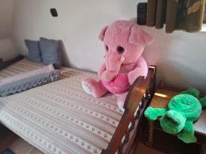 a pink teddy bear sitting on top of a bed at Villa Vadása Vendégház in Hegyhátszentjakab