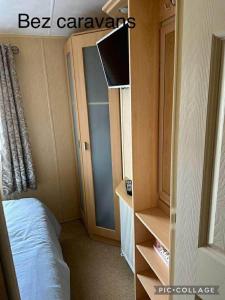 a bedroom with a bed and a book shelf at Towyn Happy Days S7 in Rowen