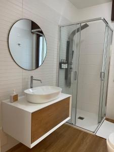a bathroom with a sink and a mirror at EOS Suite Apartment - a due passi da Piazza Pisanelli e Ospedale Panico in Tricase +59 photos