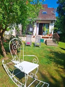 a white bench in the yard of a house at Villa Vadása Vendégház in Hegyhátszentjakab