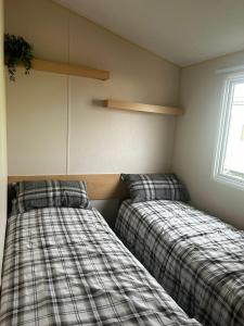 two beds sitting next to each other in a room at Buttercup Retreat 298 northfield in Skipsea