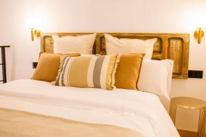 a bedroom with a large bed with brown and white pillows at Apartamentos Princesa Hayla in Caravaca de la Cruz
