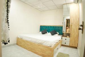 a bedroom with a bed with a blue headboard at Maneva Comforts in Mangalore