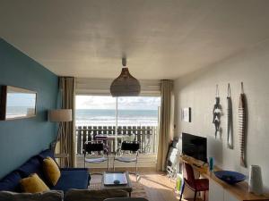 a living room with a couch and a view of the ocean at Ocean View Oceanide in Lacanau-Océan