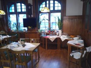 a dining room with tables and chairs and windows at Weißes Roß Crossen in Ahlendorf