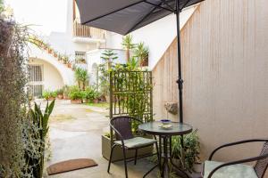 a patio with a table and chairs and an umbrella at La Culla di Adeodata in Marsala