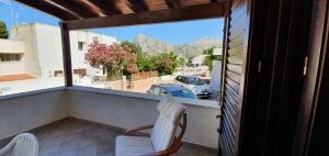 a balcony with two chairs and a view of a car at Residenza Zuc in San Vito lo Capo