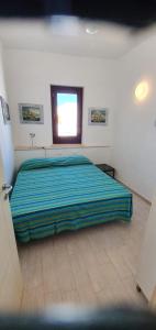 a bedroom with a bed and a window at Residenza Zuc in San Vito lo Capo