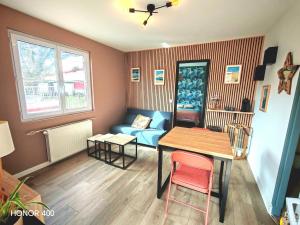 a living room with a table and a blue couch at Appartement à la Hume in Gujan-Mestras
