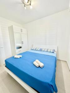 a white bedroom with two towels on a blue bed at Mareline Seafront in Fano +11 photos
