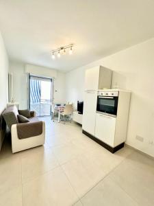 a kitchen and living room with a couch and a stove at Mareline Seafront in Fano