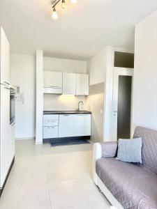 a living room with a couch and a kitchen at Mareline Seafront in Fano