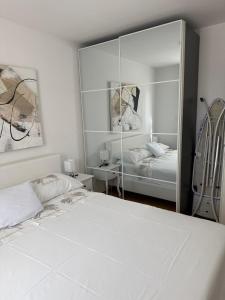 a bedroom with a white bed and a mirror at Apartment Perla in Dinjiška