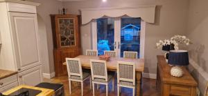 a dining room with a wooden table and chairs at Rockleigh House in Corsham +12 photos