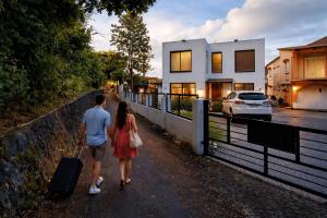 a man and woman walking down a street with a suitcase at Hill Venue in Coquinbourg