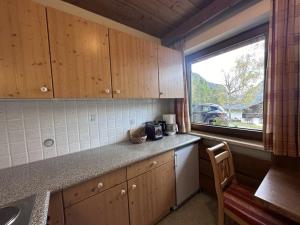 a kitchen with wooden cabinets and a window and a sink at Chalet Villa Josi Superior Appartement 11 in Leutasch