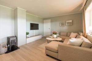a living room with a couch and a fire place at Modern Fjord View Apt near City in Tromsø