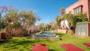 a backyard with a swimming pool in the grass at Dar Alba in Marrakesh
