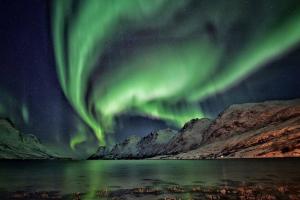an image of the aurora in the sky over a lake at Modern Fjord View Apt near City in Tromsø