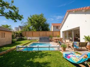 a backyard with a swimming pool and a patio at Maison Nova in Talant